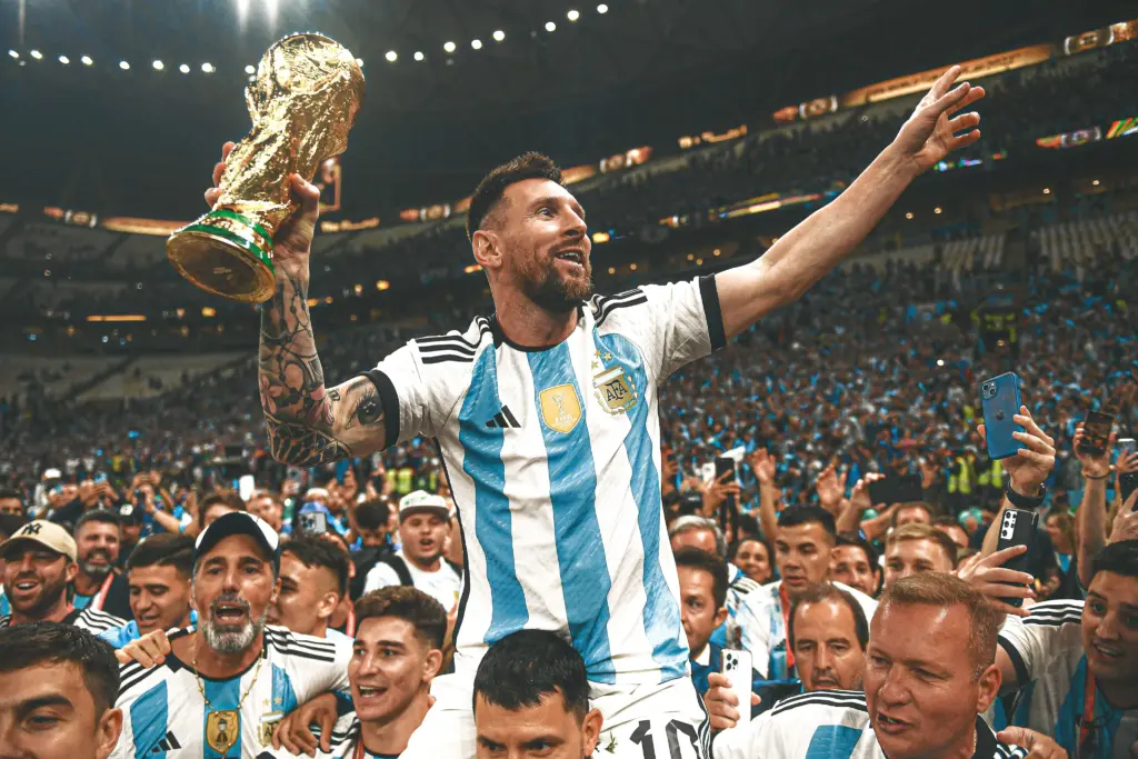 Lionel Messi holding the World Cup trophy and celebrating